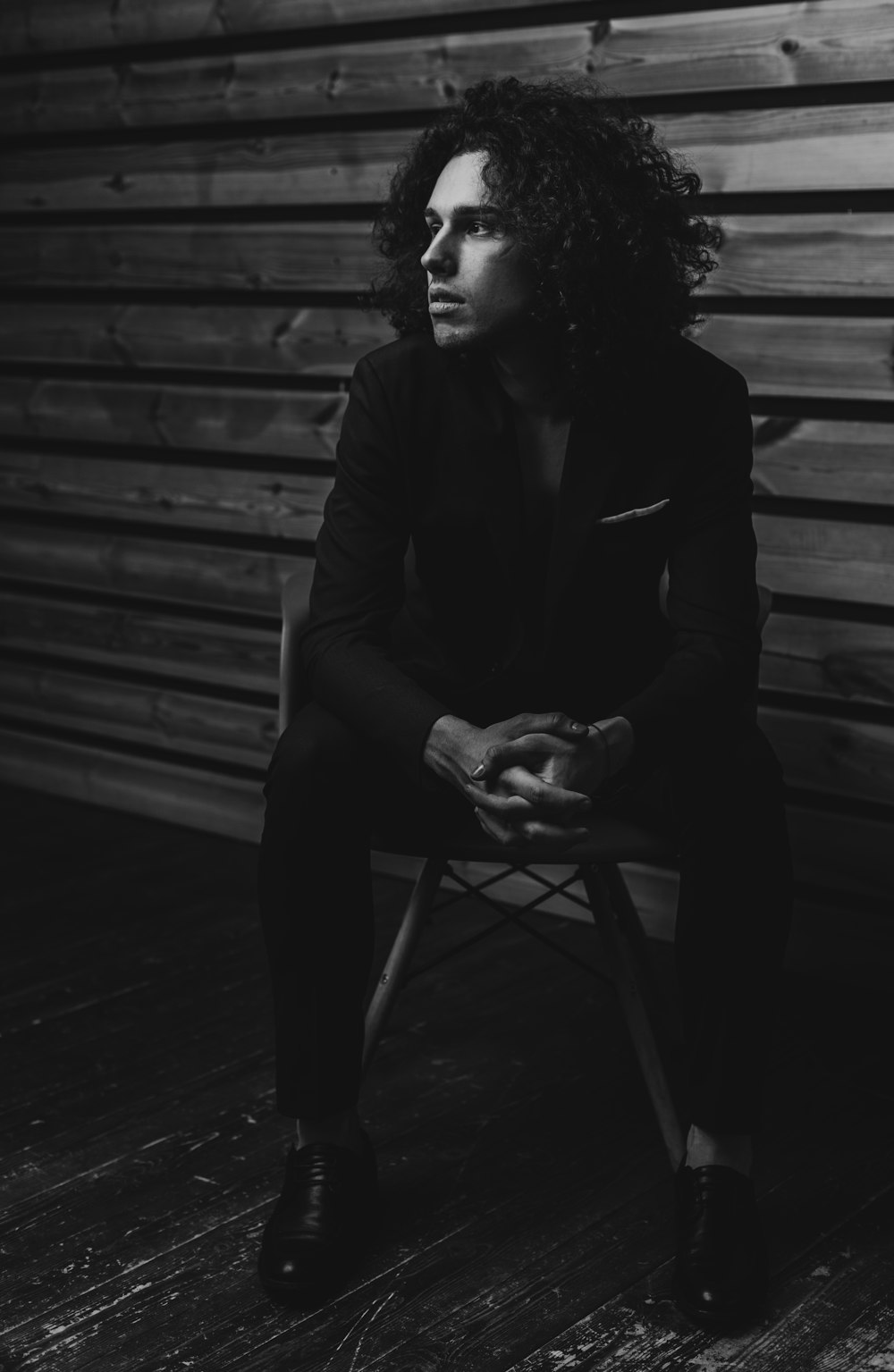 man in black suit jacket sitting on chair