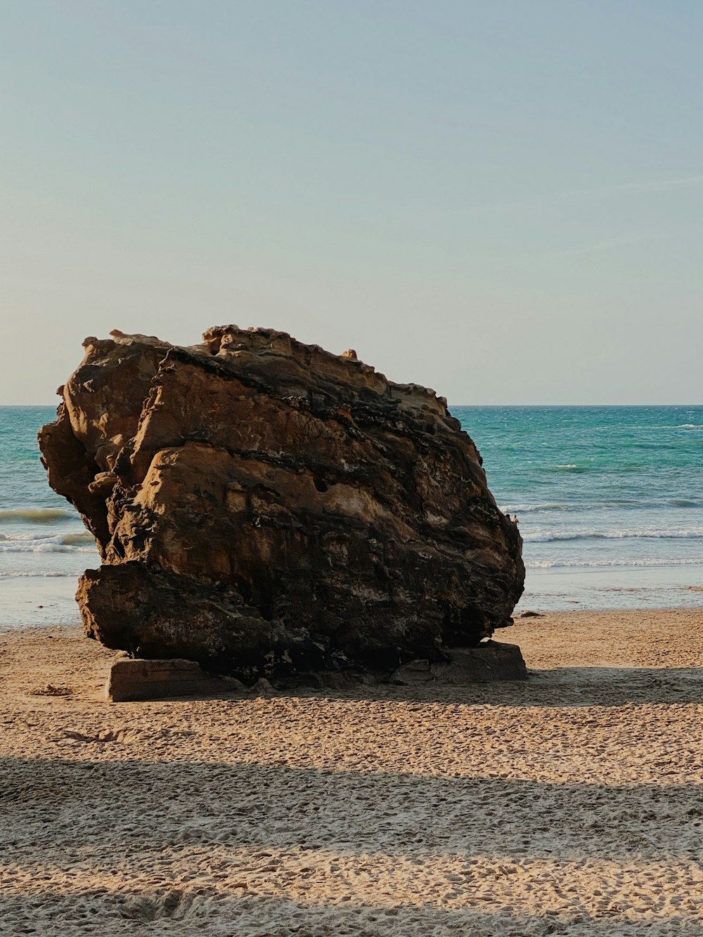 brown rock formation on beach during daytime