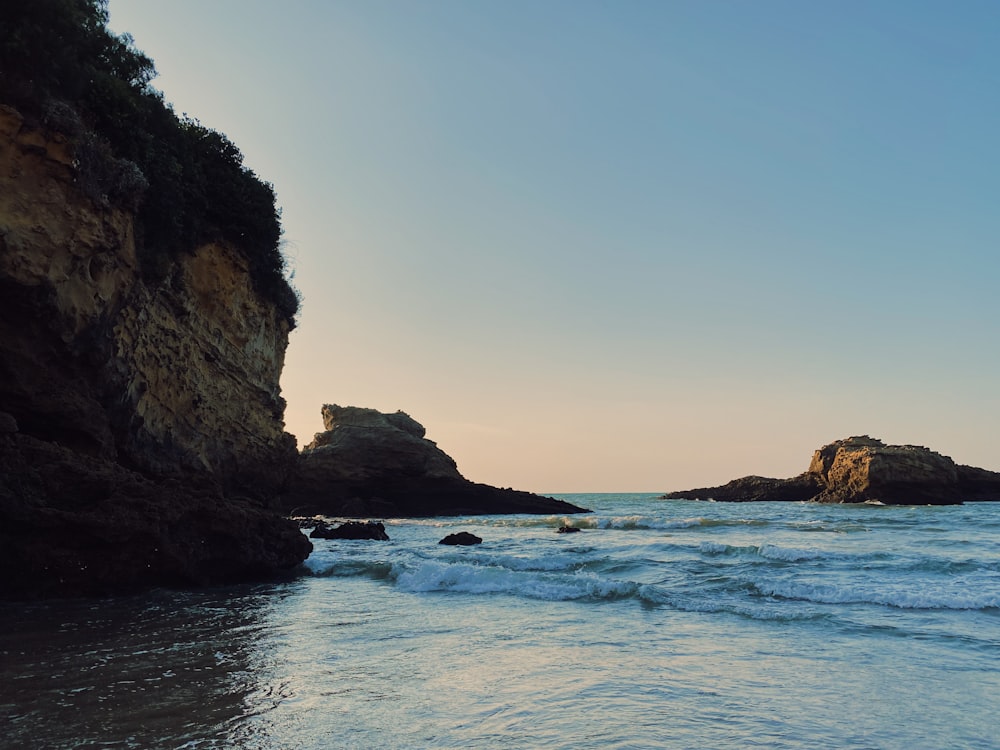 brown rock formation on sea during daytime