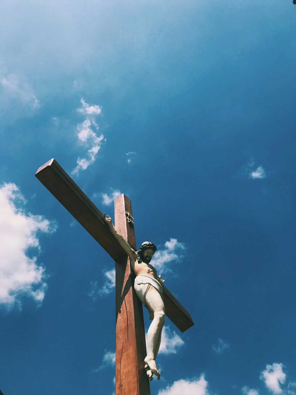 cruz de madera marrón bajo el cielo azul durante el día