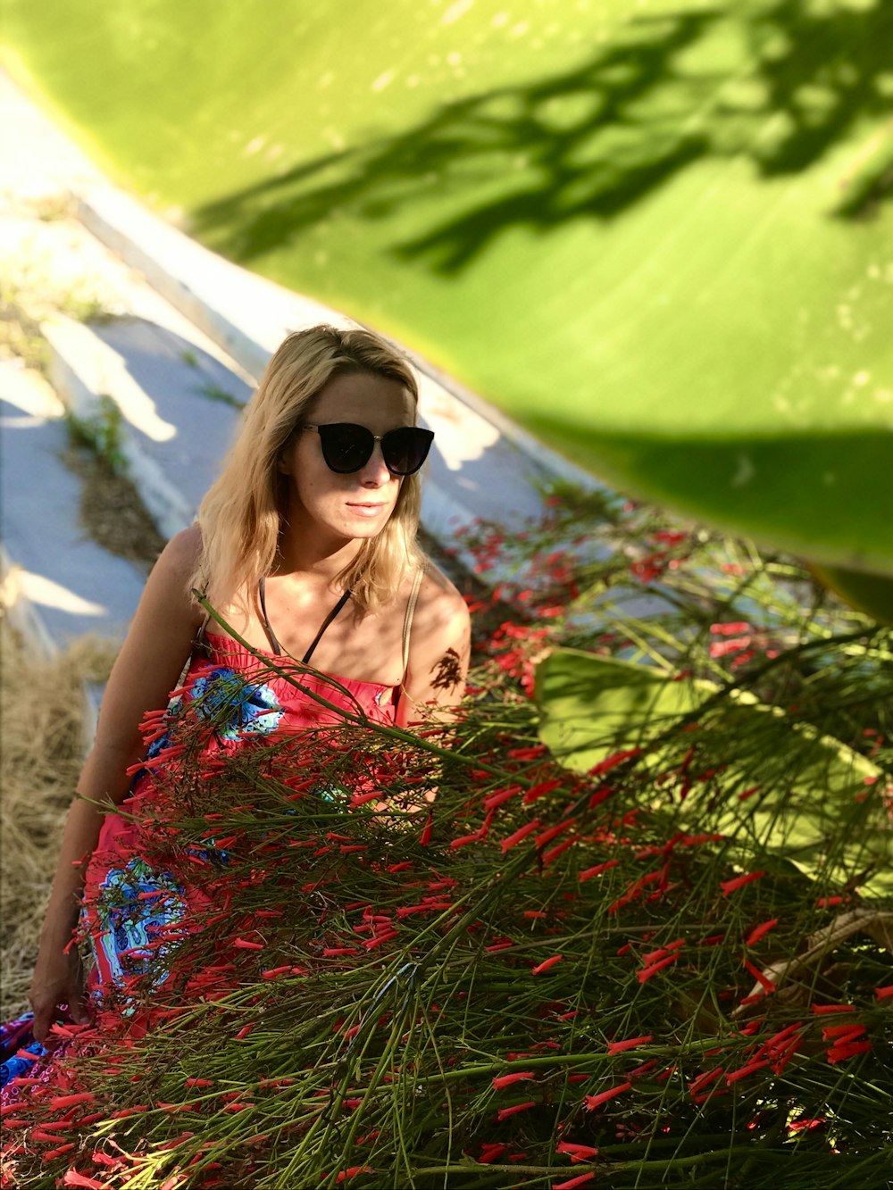 woman in green and red floral spaghetti strap dress wearing black sunglasses