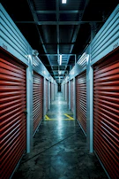 A well-lit storage facility corridor showing multiple secured units.