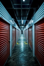 A bright, clean storage facility hallway with neatly arranged climate-controlled units.