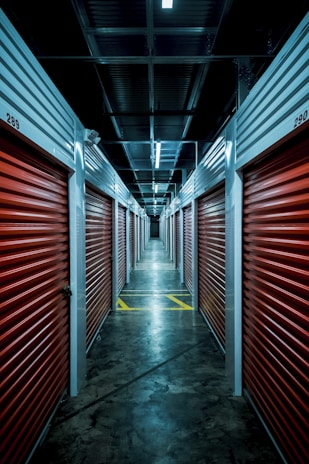 A well-lit hallway of storage units with open doors.