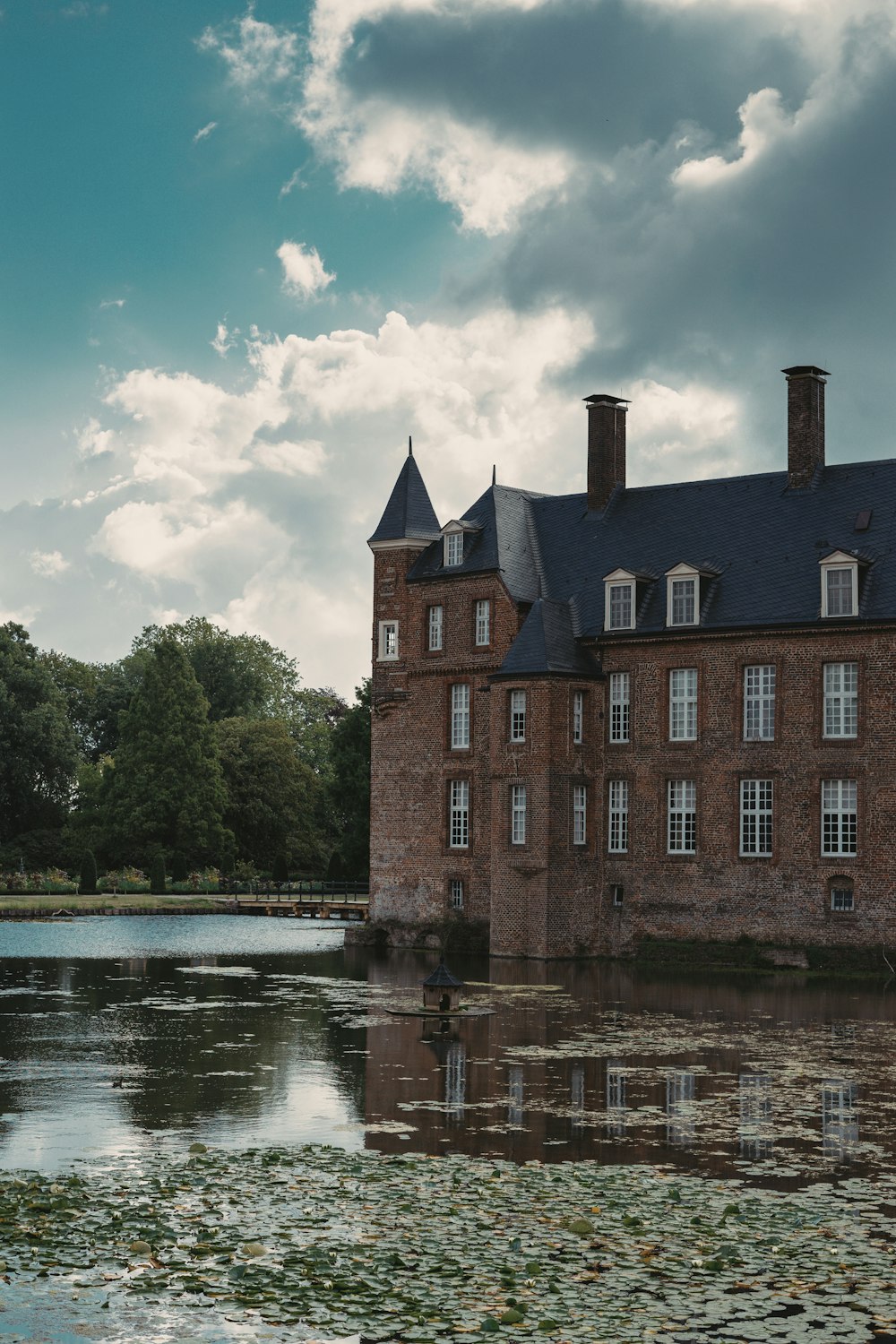 Edificio in cemento marrone vicino al fiume sotto il cielo blu durante il giorno