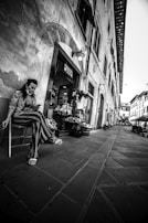 Annette smiling warmly while chatting on her laptop, parked by a quiet European village street.
