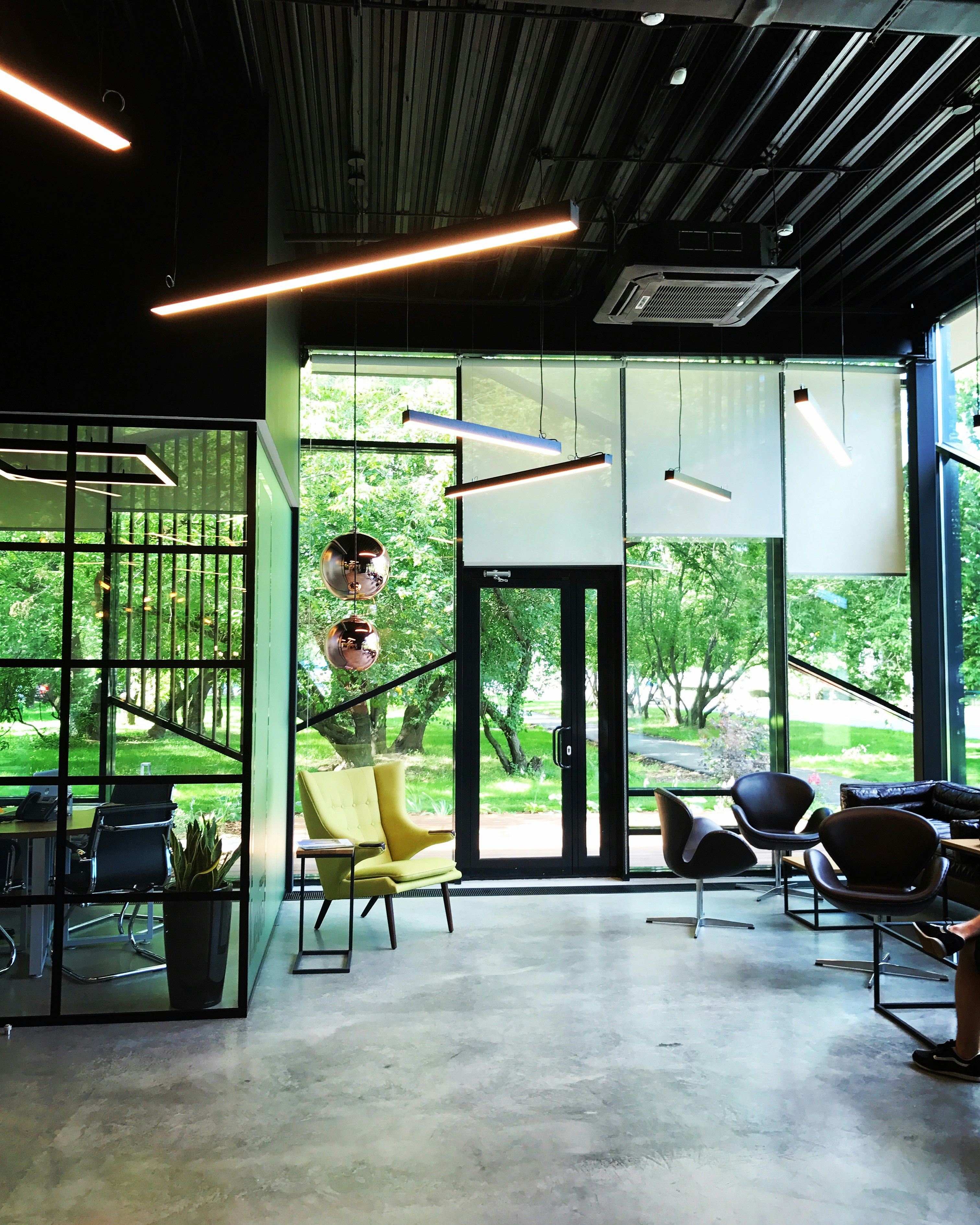 woman in green shirt standing near glass window