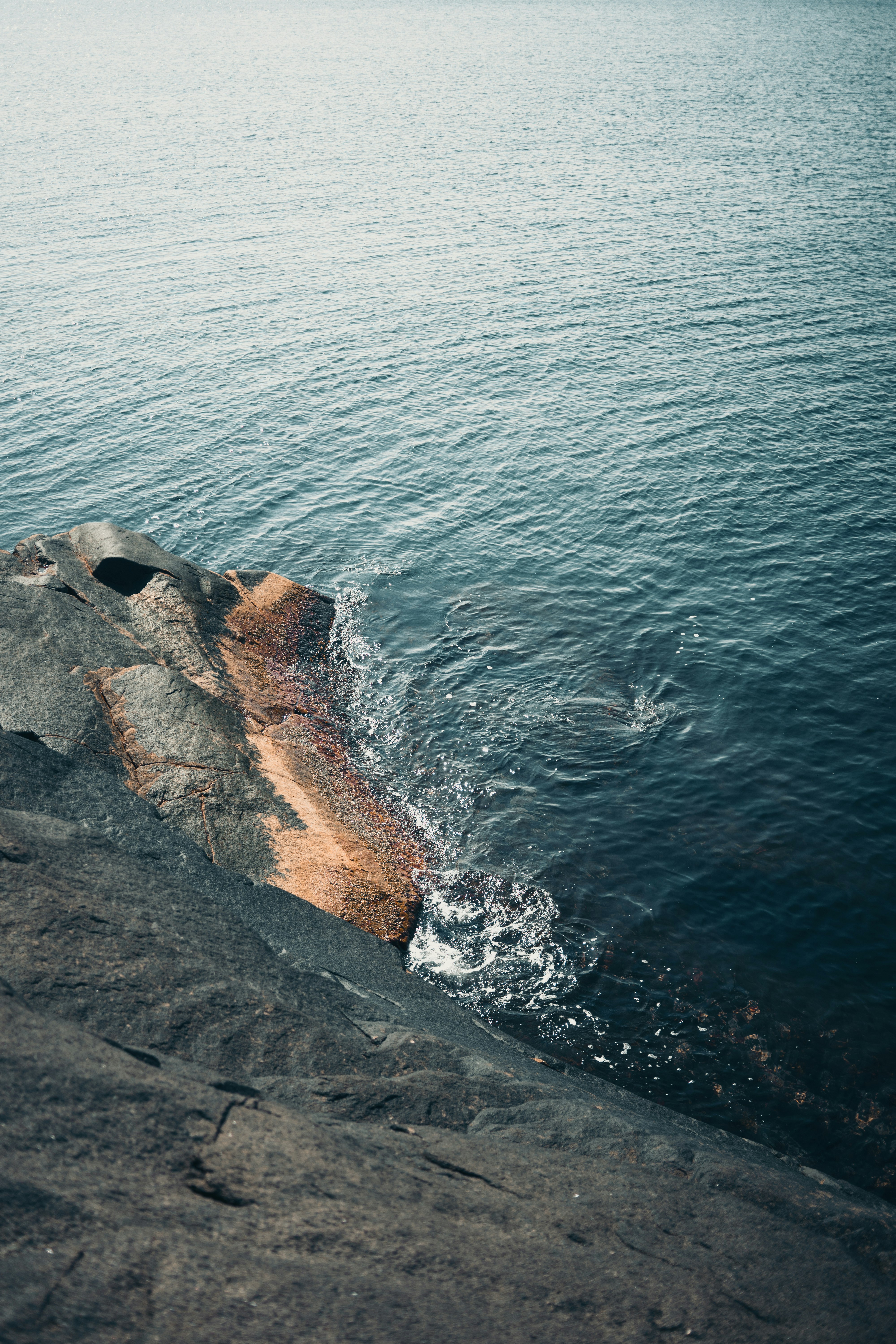 brown rock formation beside body of water during daytime