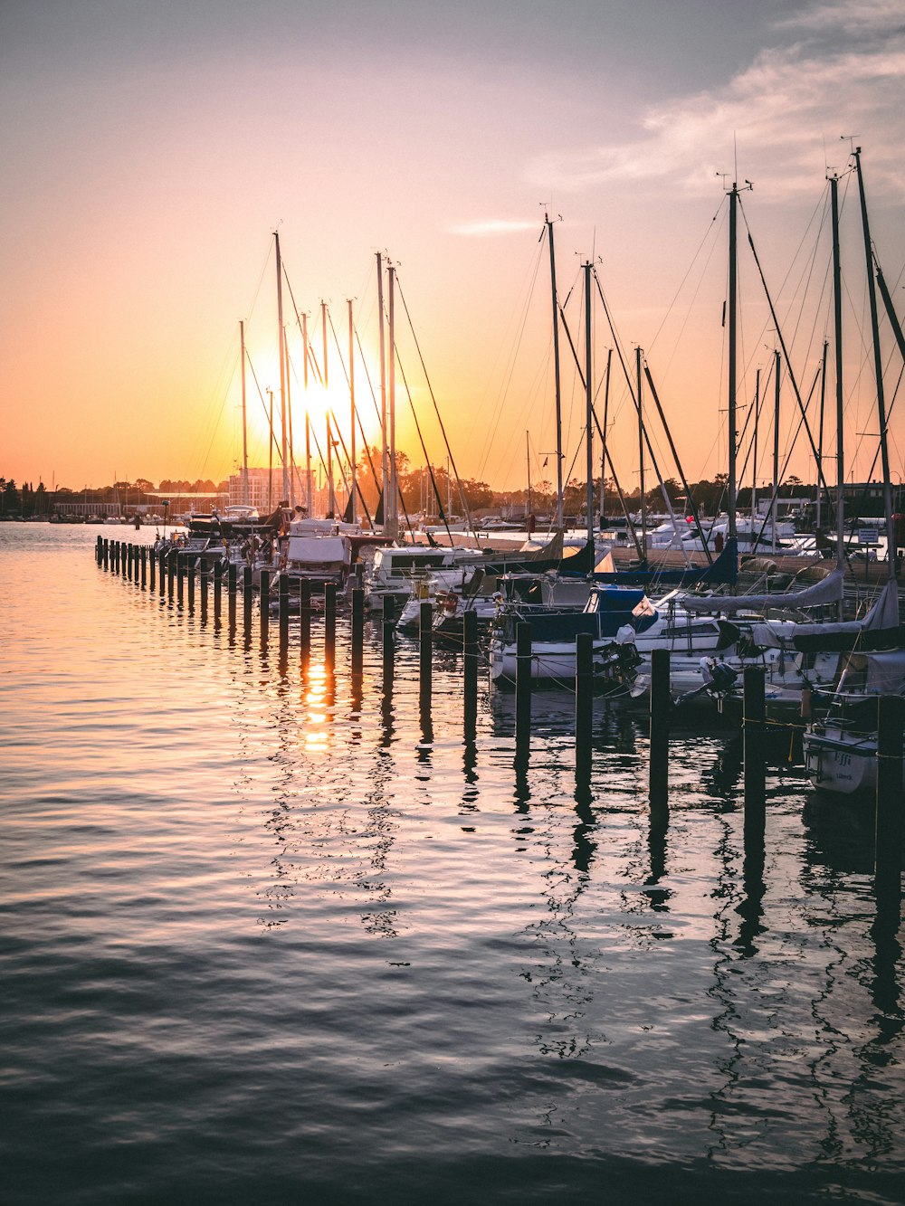 white and blue boats on sea during sunset