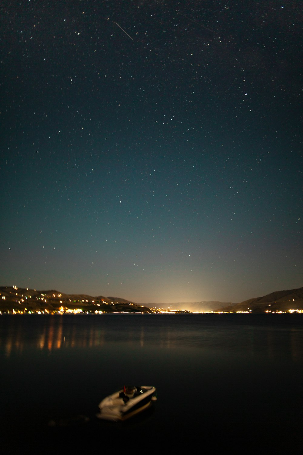 body of water near mountain during night time