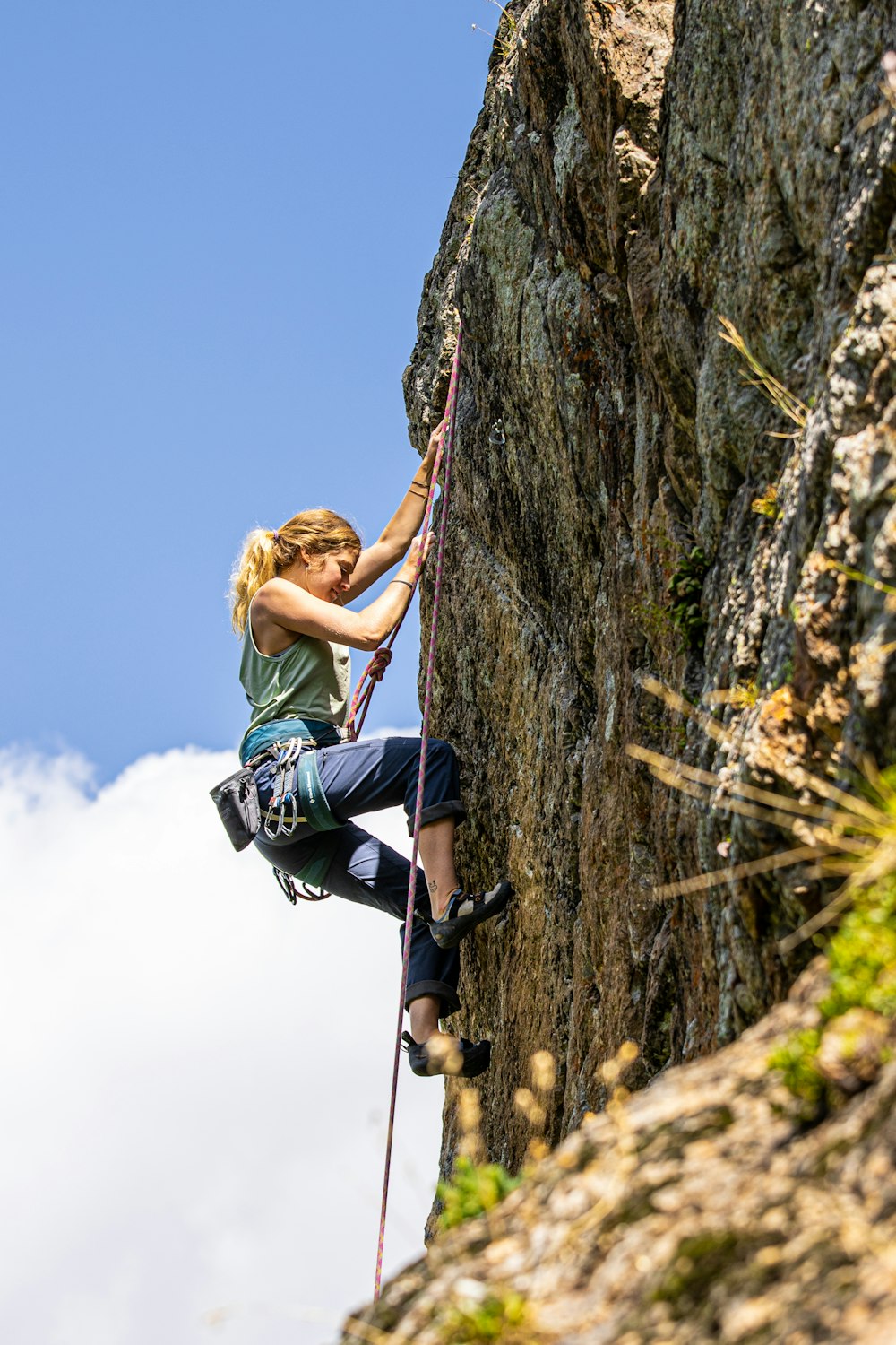 Eine Frau, die auf einen Berg klettert