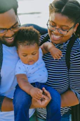 woman in black and white striped shirt carrying baby in white onesie