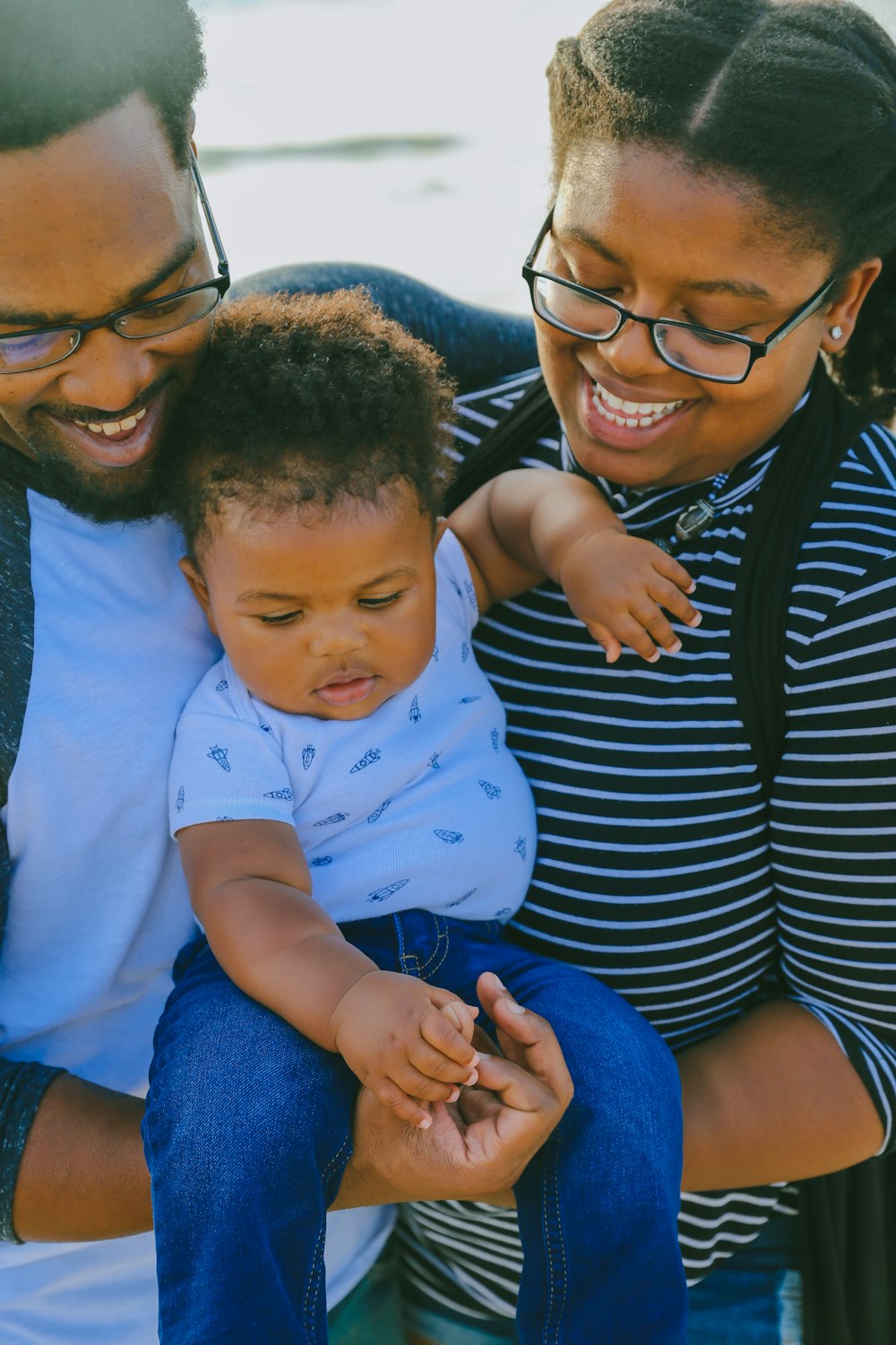 woman in black and white striped shirt carrying baby in white onesie