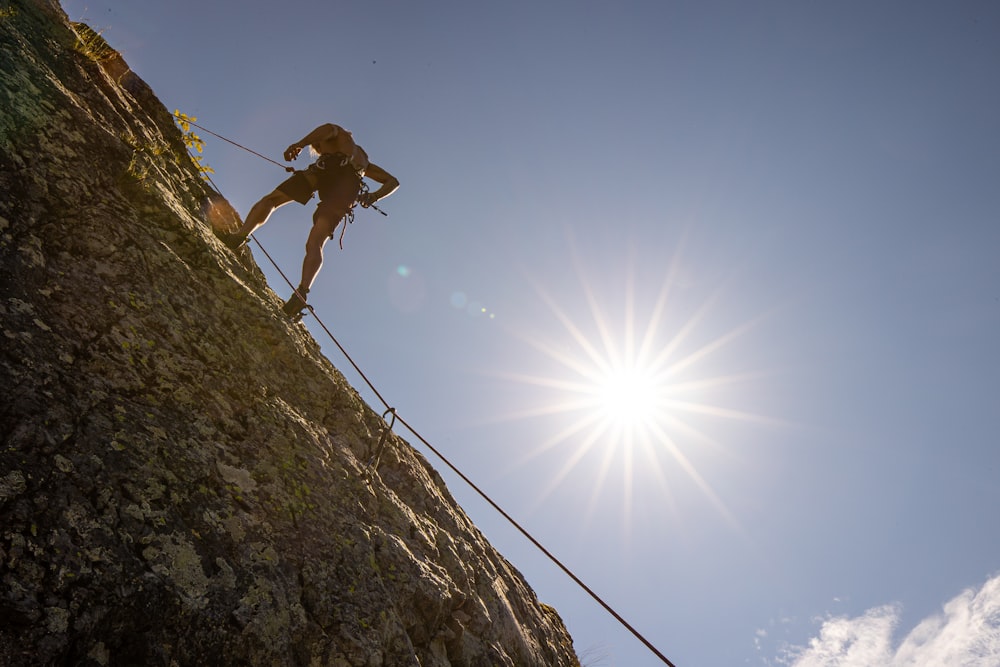 a man climbing up the side of a mountain