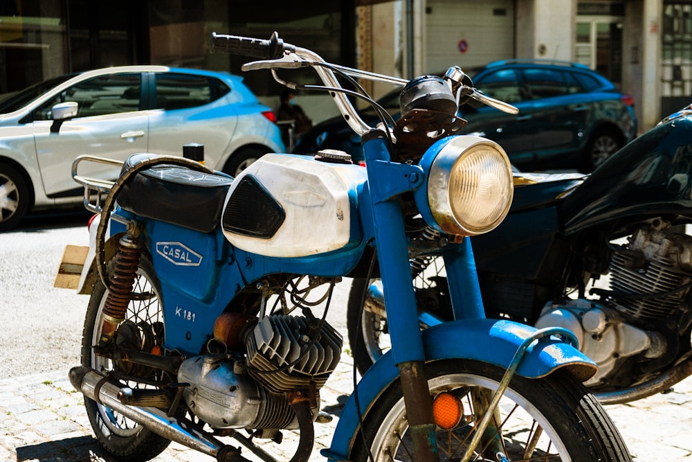 blue and silver motorcycle near blue car