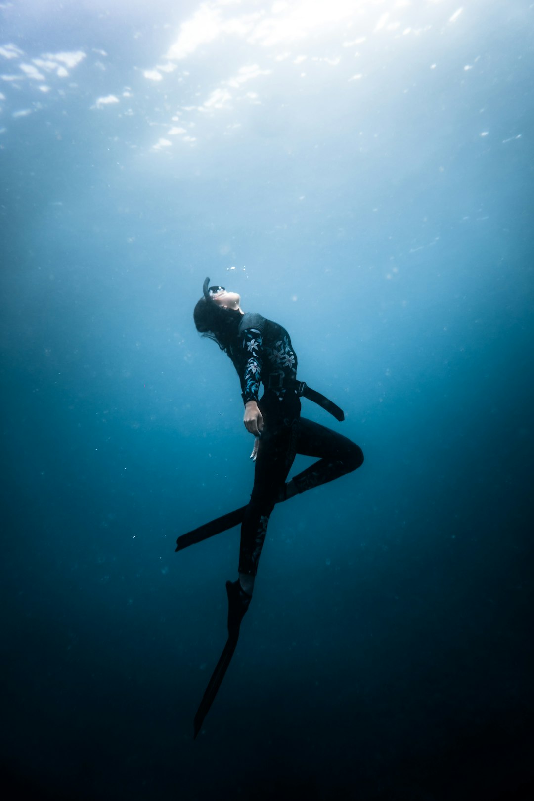 man in black wet suit under water