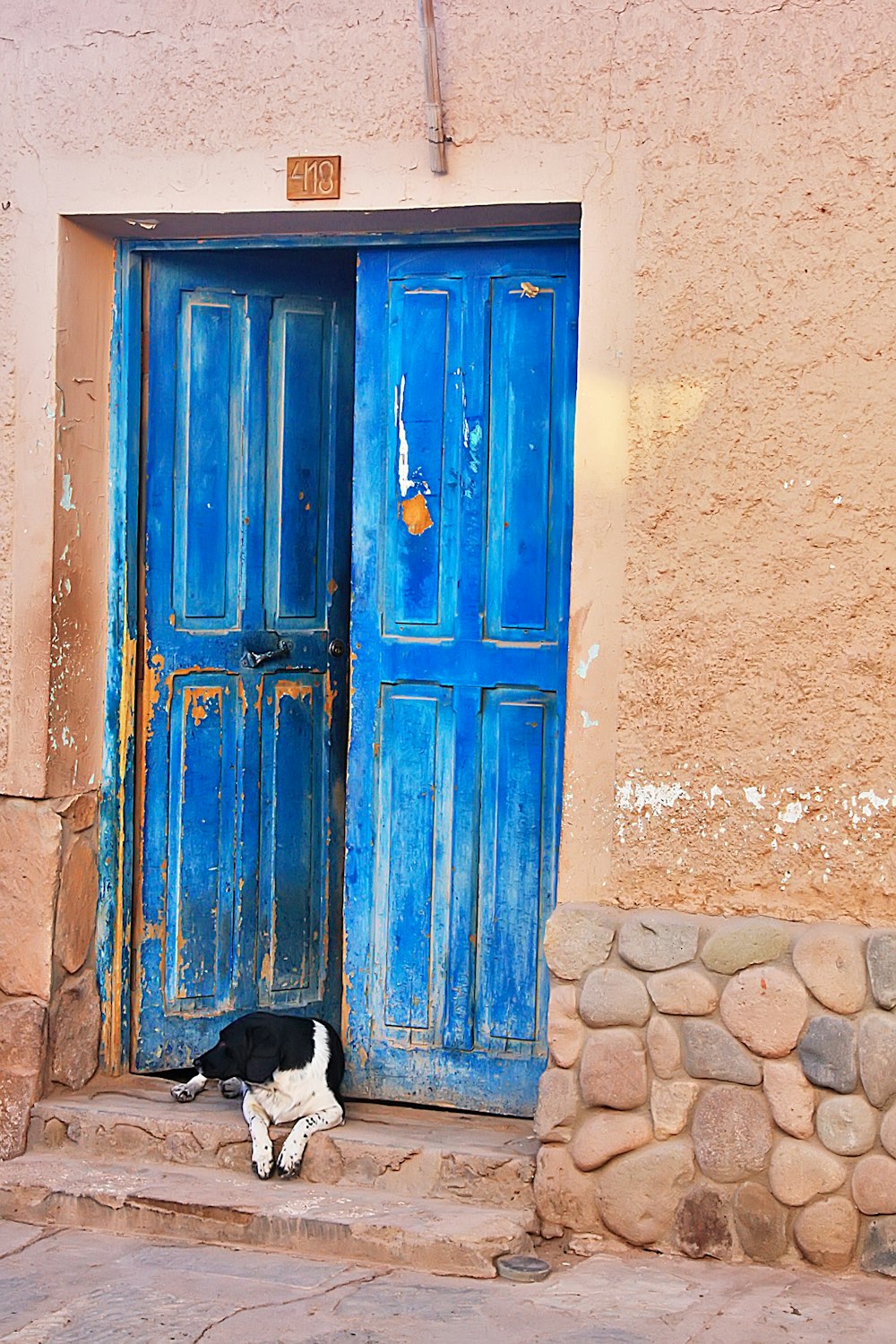 blue wooden door on brown concrete wall