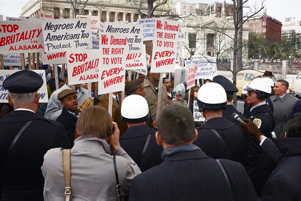 Des manifestants afro-américains devant la Maison Blanche, avec des pancartes réclamant le droit de vote et protestant contre la brutalité policière contre les manifestants des droits civiques à Selma, en Alabama