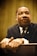 A focused individual in a business suit, engaged in a thoughtful discussion with a mentor.