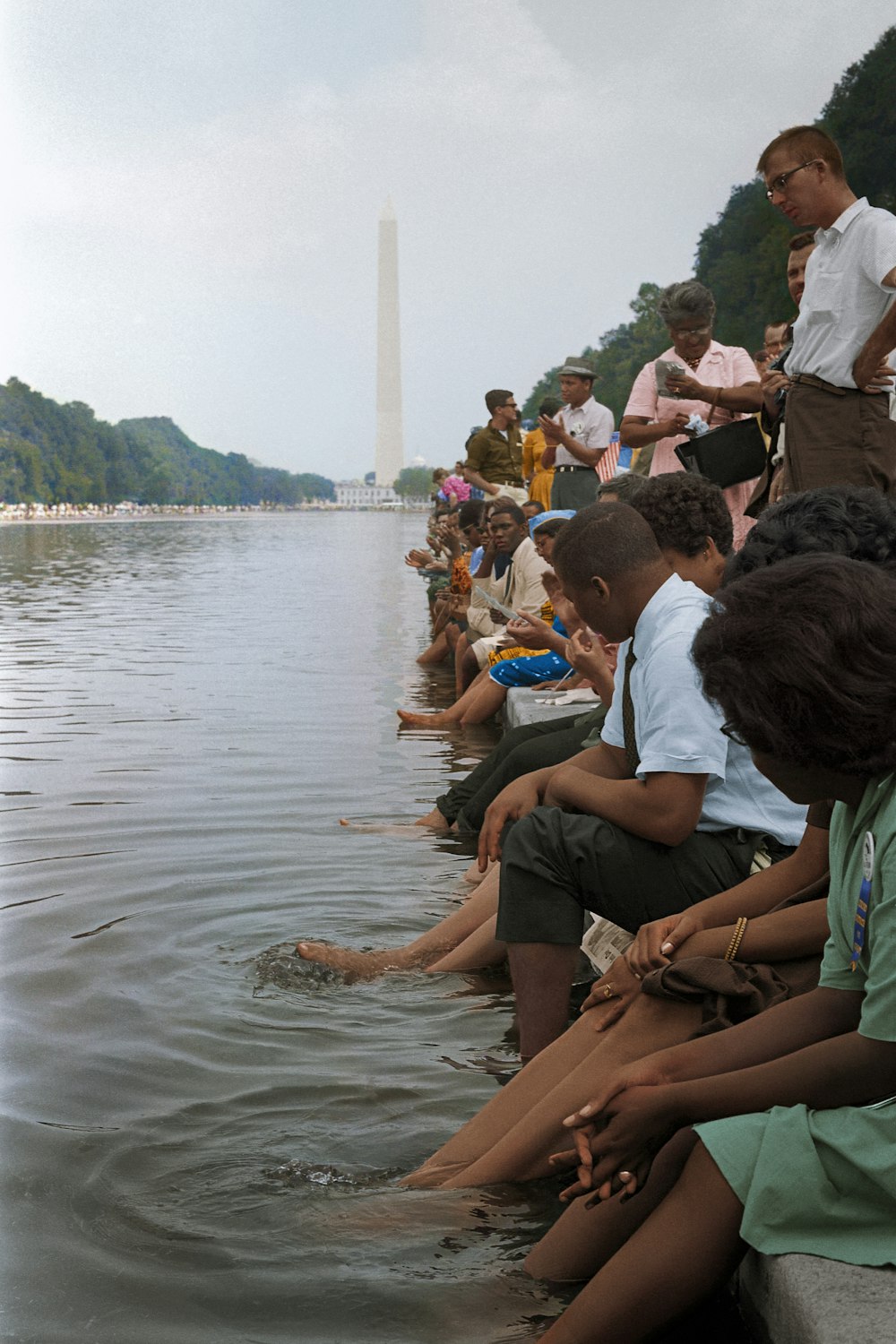 1963年のワシントン大行進でリフレクティング・プールに足を入れて座るデモ参加者