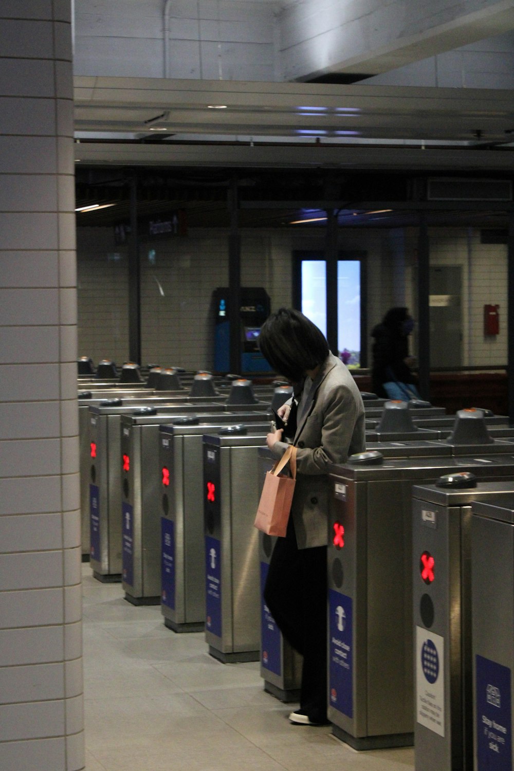 woman in gray jacket standing in front of gray metal cabinet