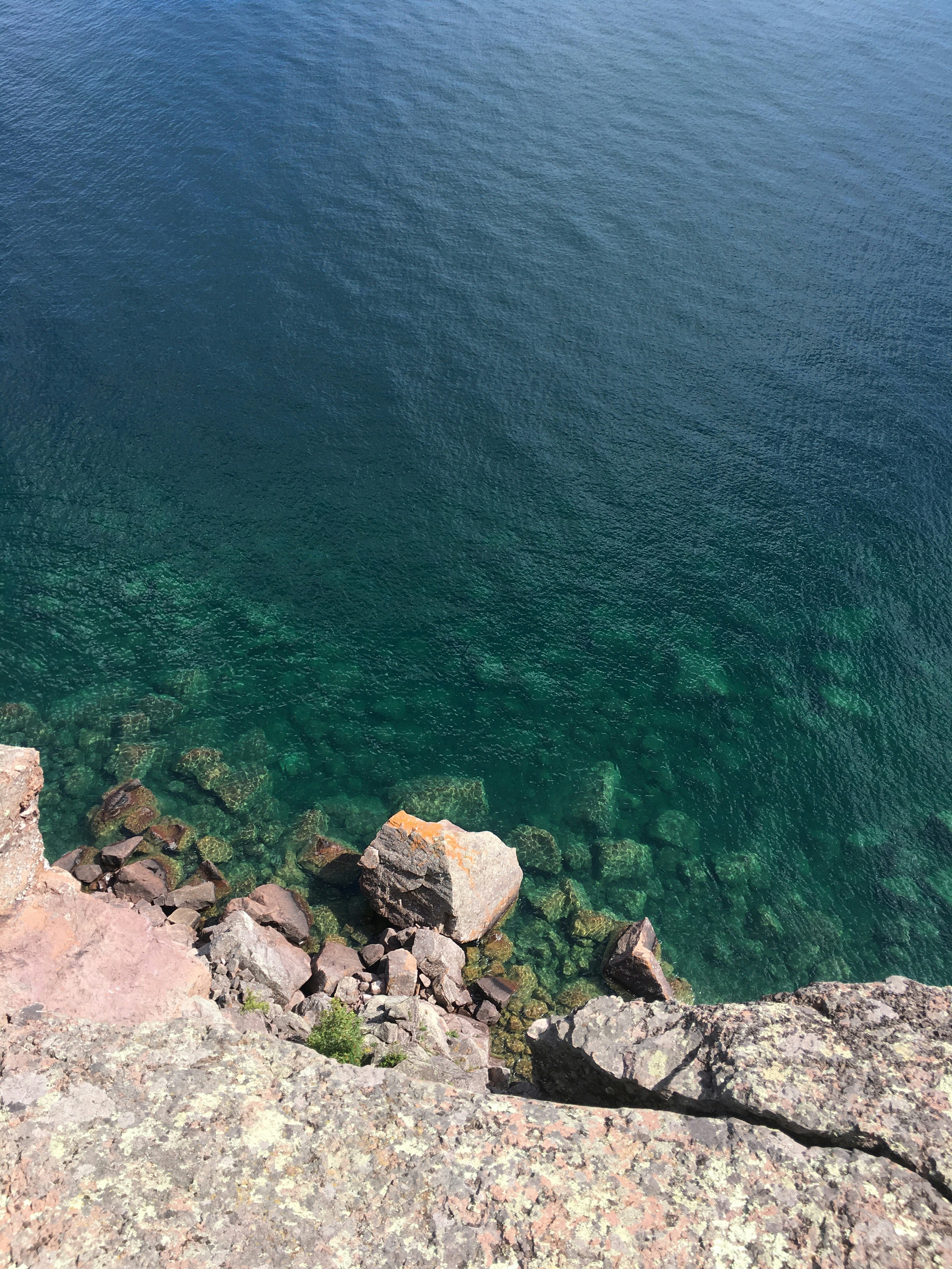 brown rocky shore with green water