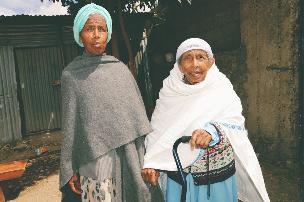 2 women in white hijab standing near green palm tree during daytime