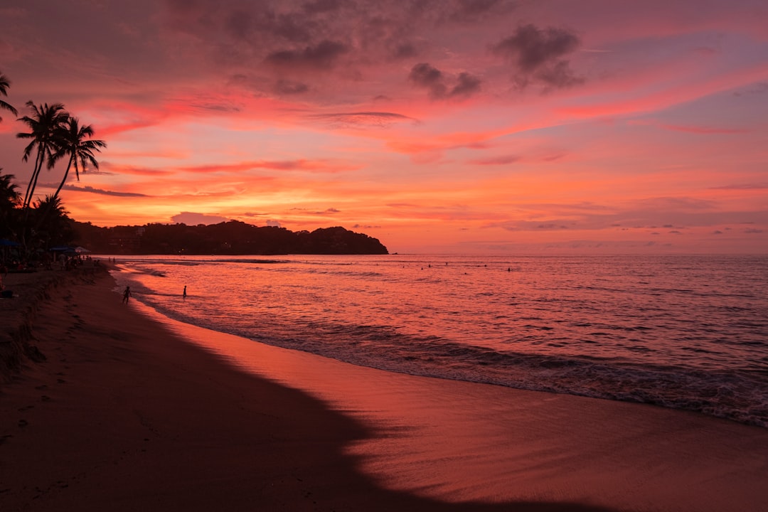 body of water under cloudy sky during sunset