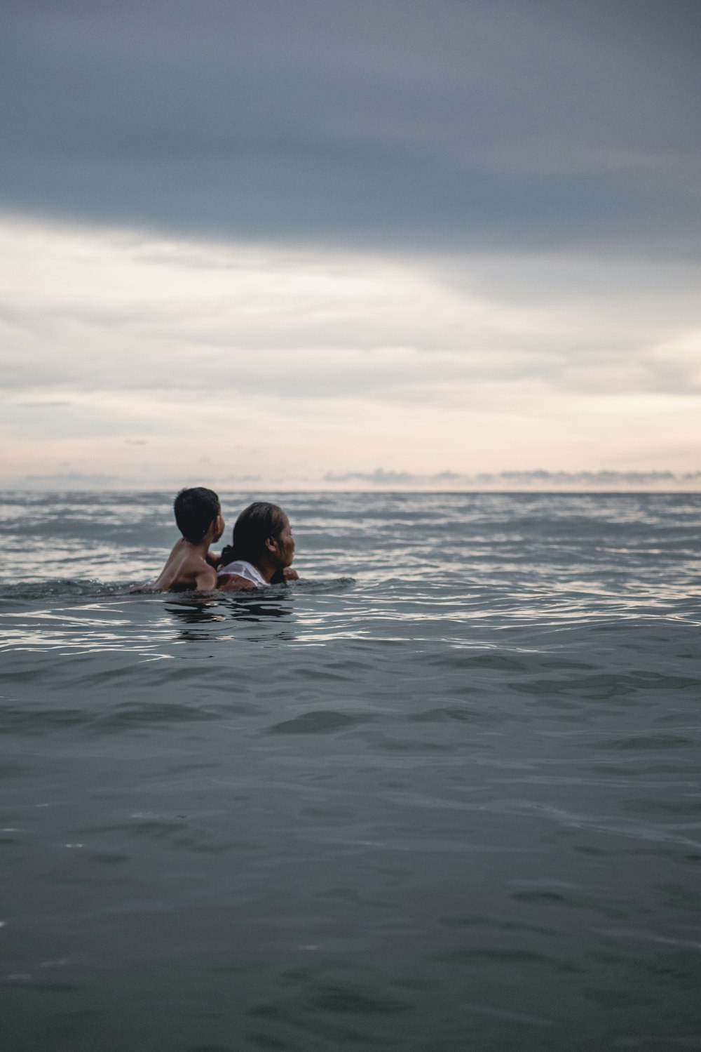 couple kissing on sea during sunset