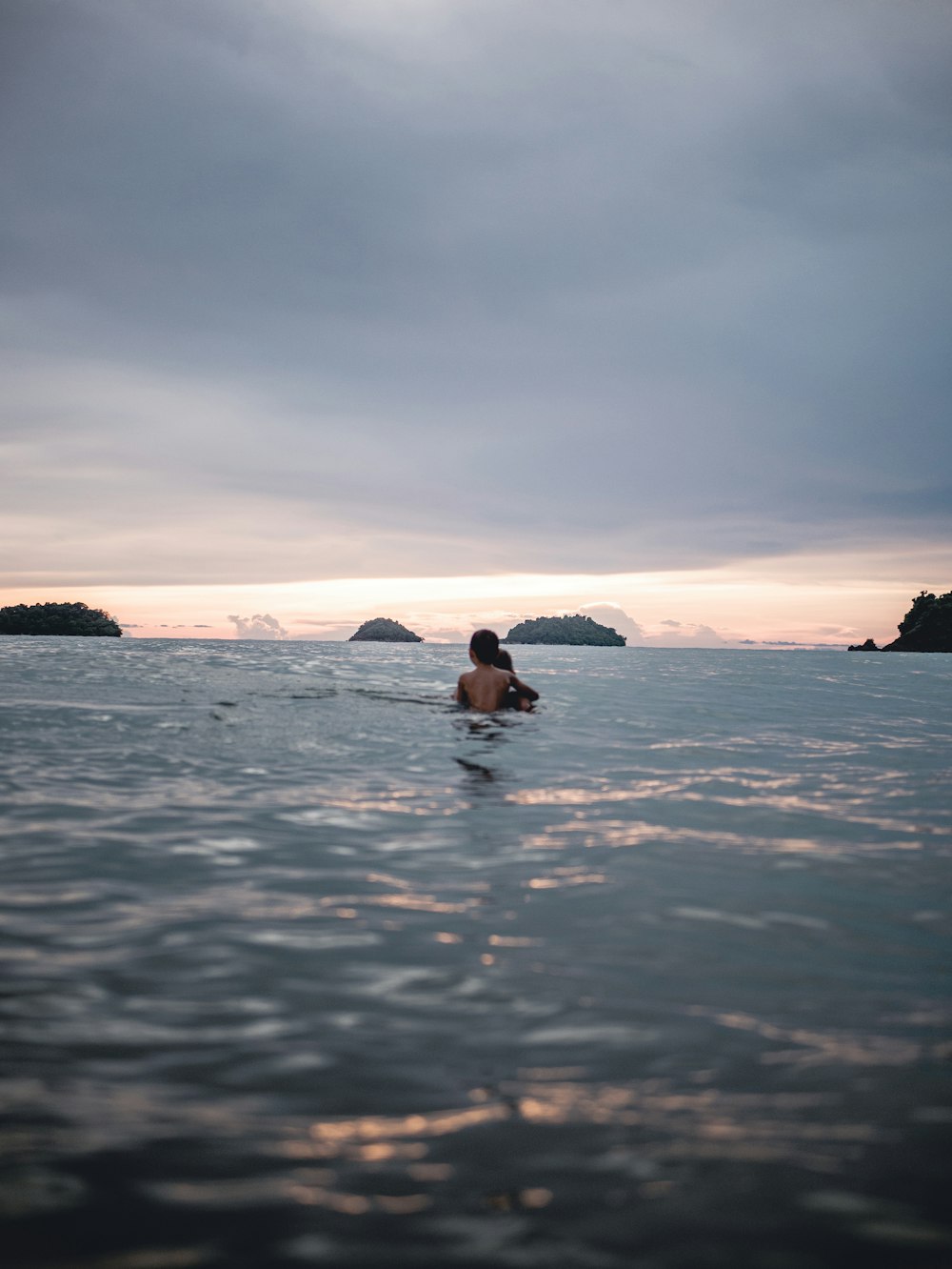 woman in black bikini on body of water during daytime