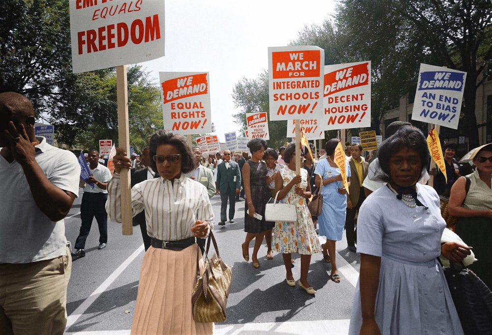 Demonstrators walk along a street holding signs demanding the right to vote and equal civil rights at the March on Washington