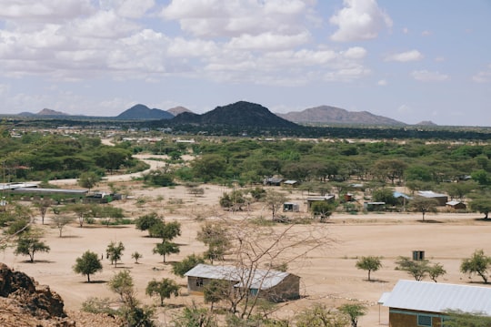 white and brown houses near green trees and mountains during daytime in Turkana Kenya