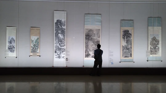 A user browsing traditional Chinese paintings on a tablet in a cozy room.