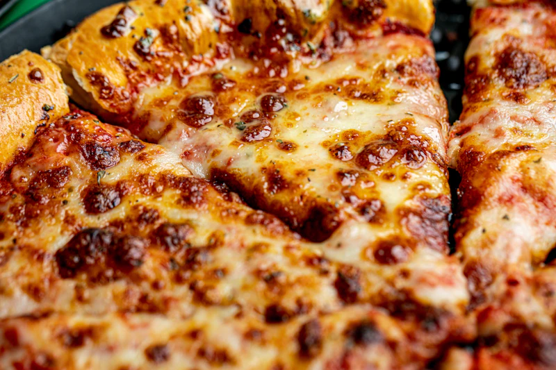 Thin-crust pizza cut into squares, tavern-style, topped with pepperoni and peppers