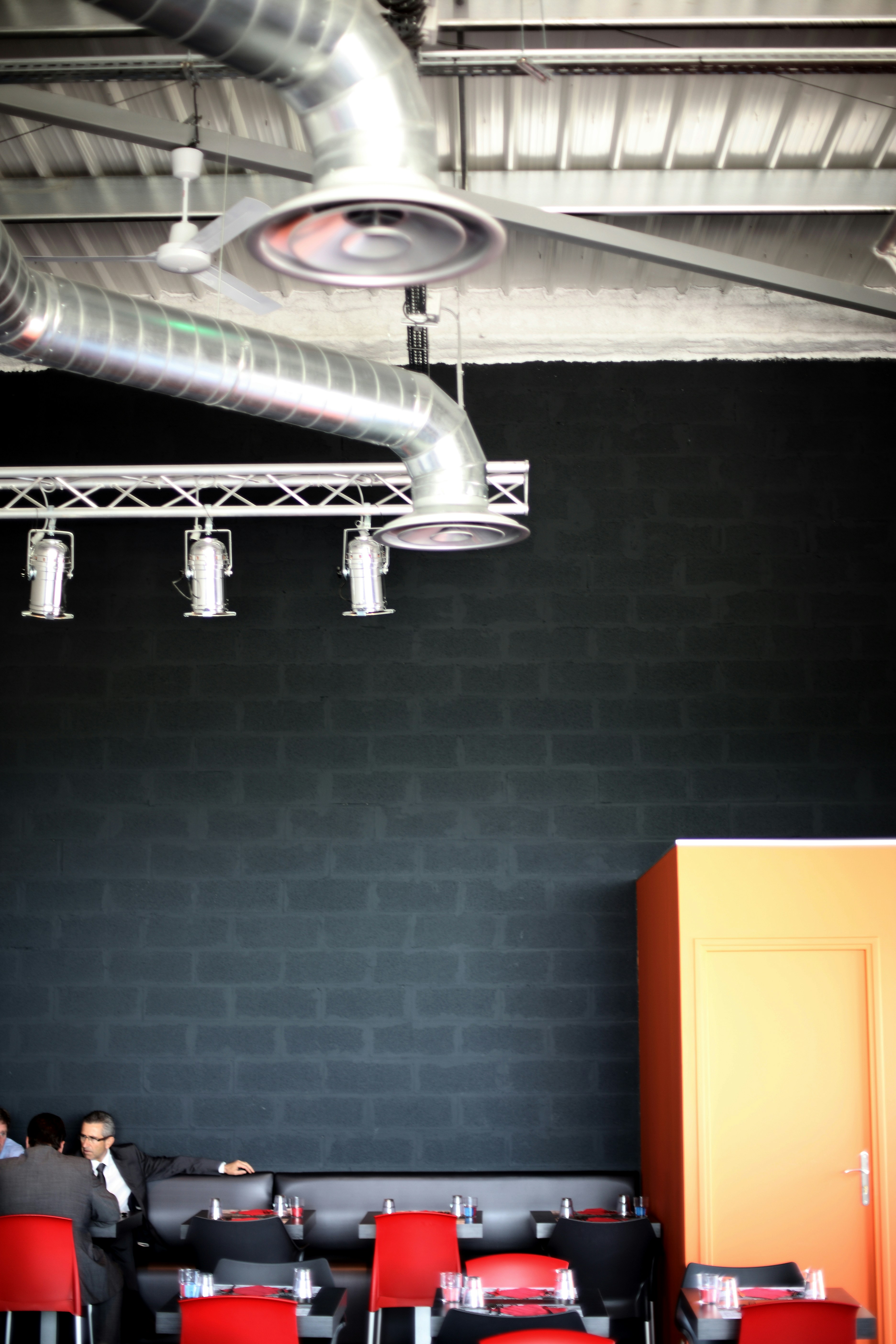 Ventilateur de plafond blanc allumé près du ventilateur mural blanc