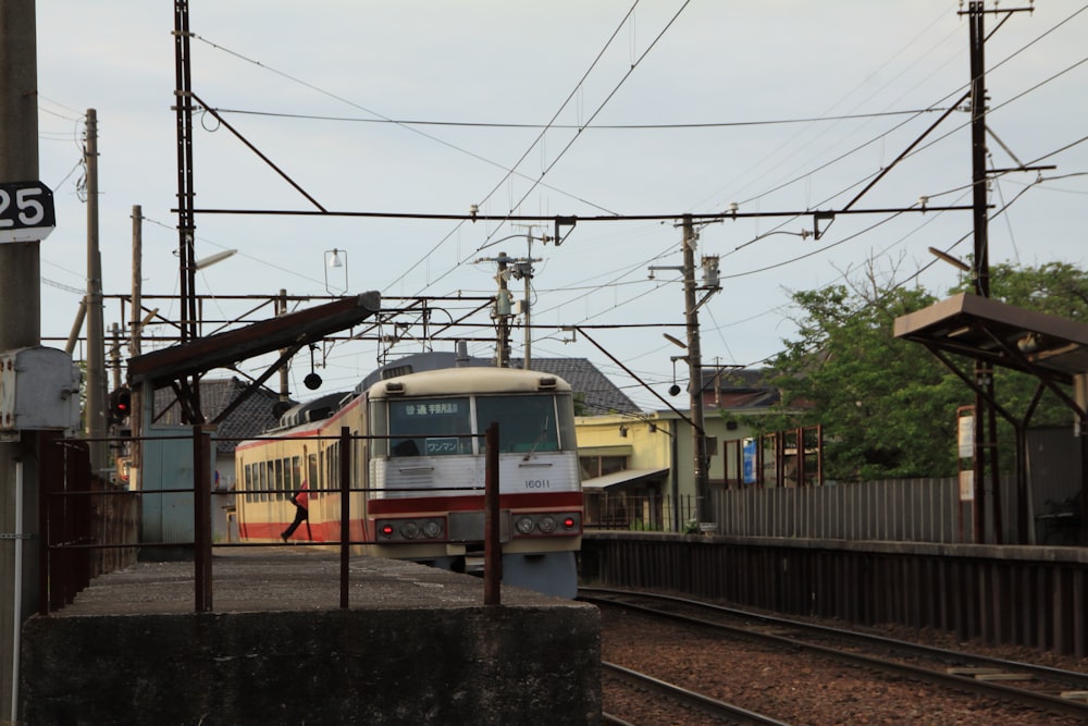 trem branco e vermelho nos trilhos durante o dia