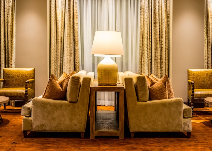 A cozy 2-seater sofa placed in a modern Riyadh living room with warm lighting.