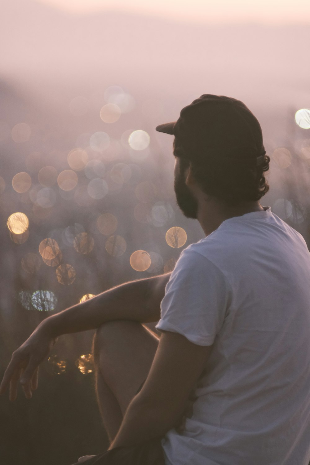 man in white t-shirt holding lighted string lights