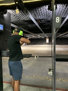 A focused shooter aiming at a target on a shooting range.