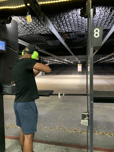 A focused shooter aiming a large caliber pistol at an outdoor range.