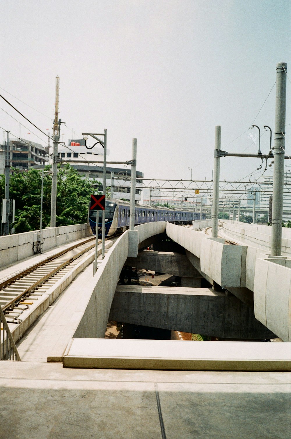 man in red jacket and blue denim jeans walking on bridge during daytime