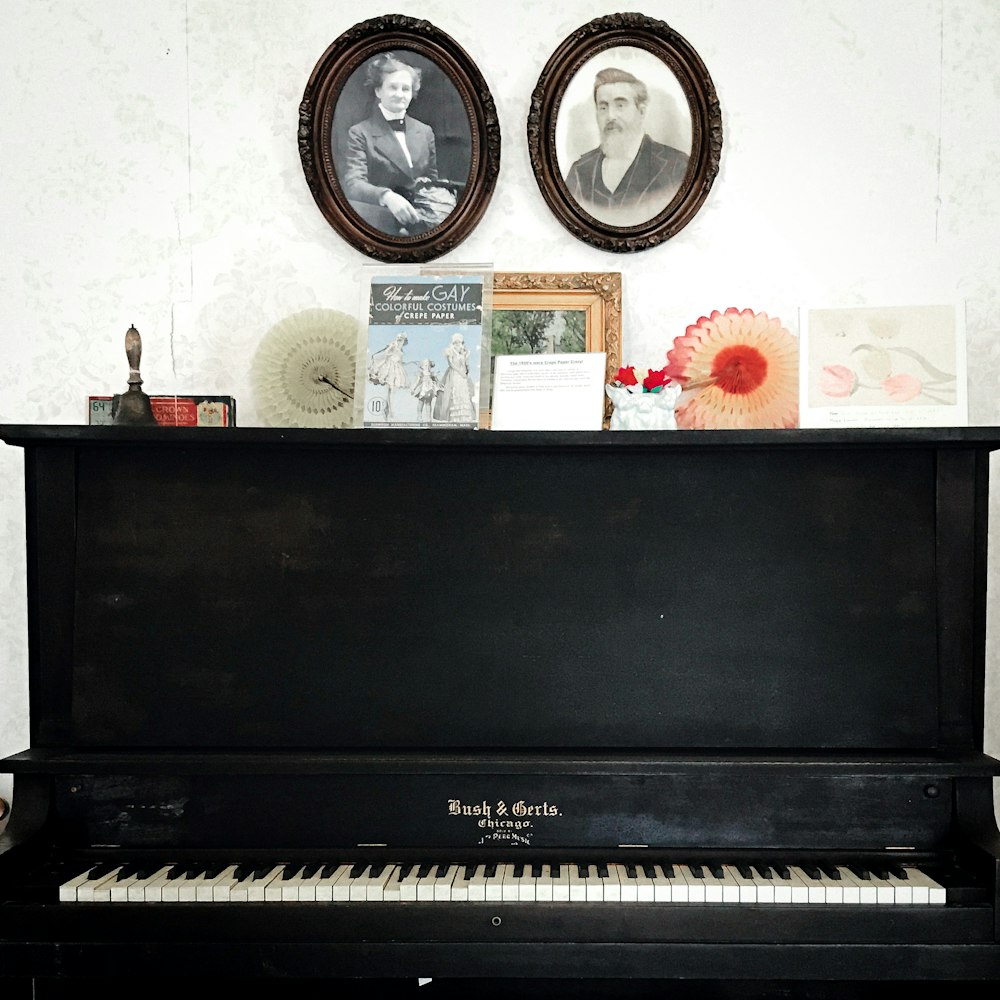black upright piano beside white wall