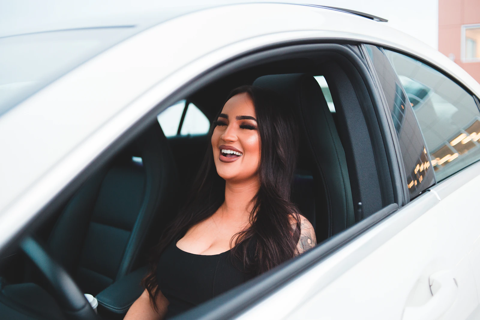 Smiling driver behind the wheel of her car