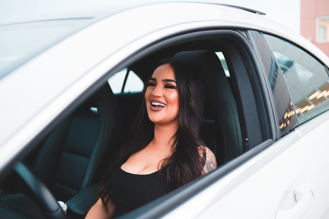 woman in black tank top smiling inside car