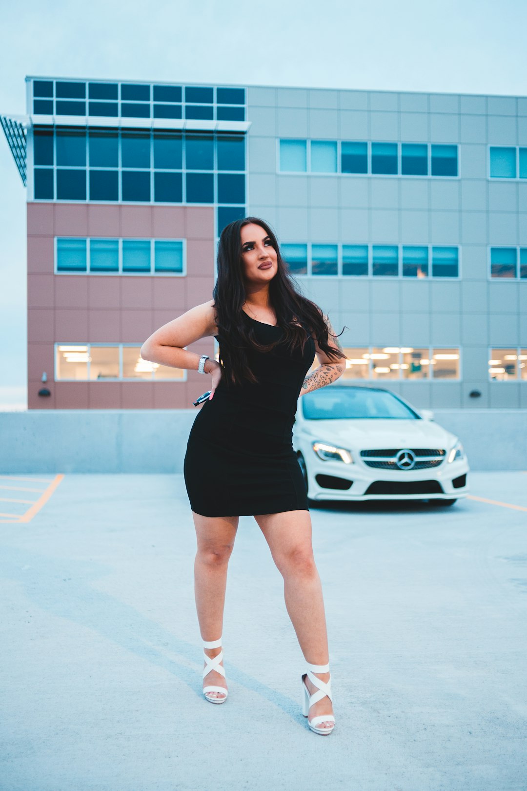 woman in black sleeveless dress standing on white concrete floor