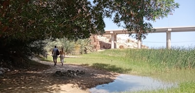 man in black jacket and black pants walking on dirt road during daytime oman google meet background