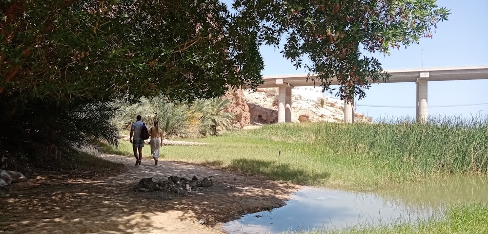 man in black jacket and black pants walking on dirt road during daytime