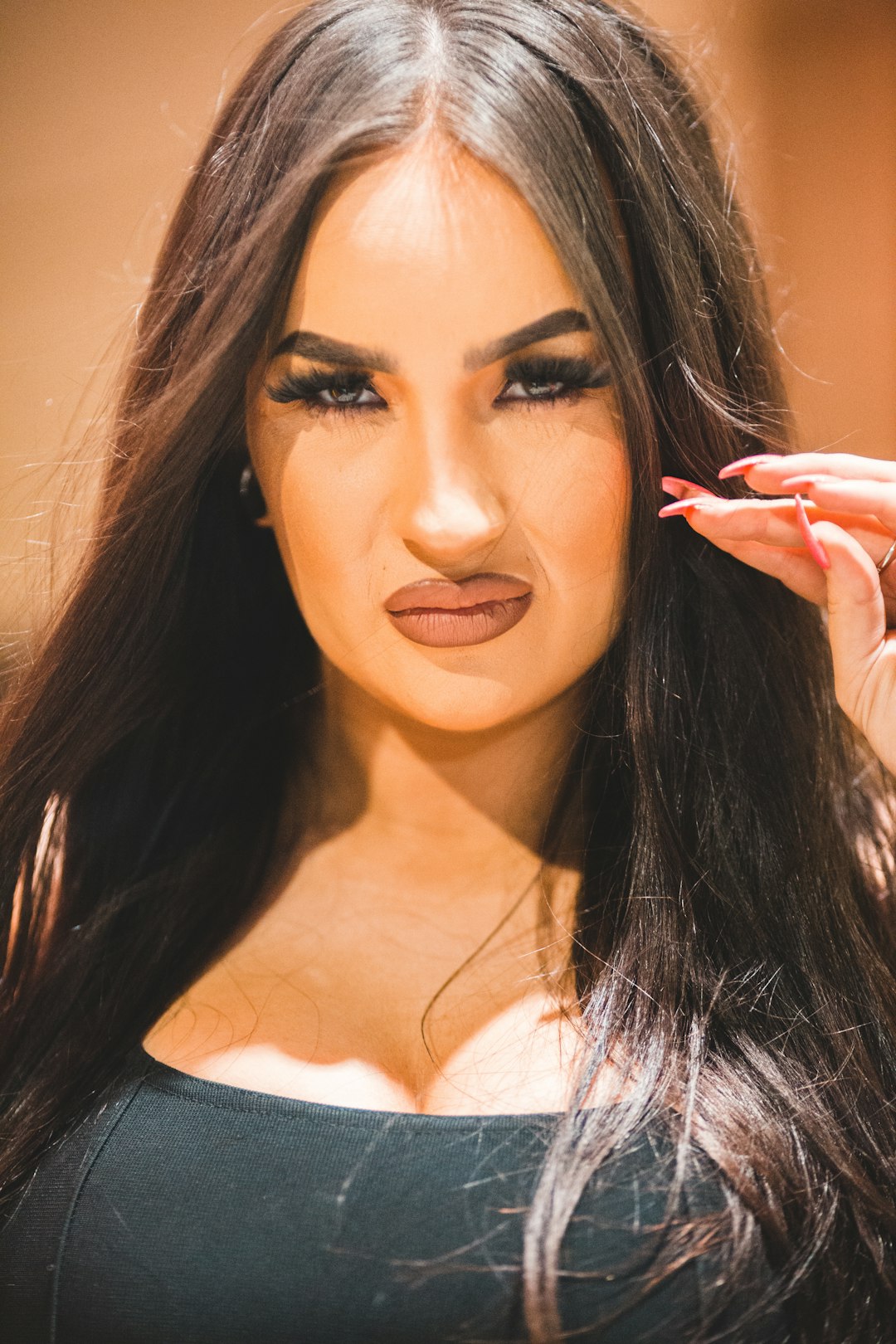 woman in white tank top holding red lipstick