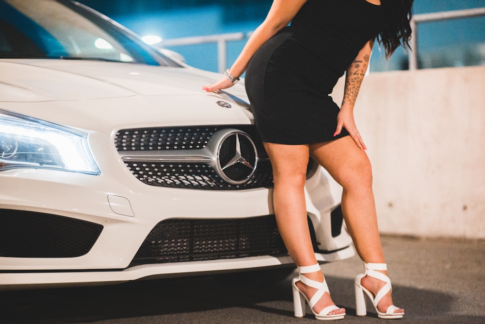 Foto Mujer en mini vestido negro y zapatos deportivos nike blancos y negros  de pie junto a un coche blanco – Imagen Beige gratis en Unsplash