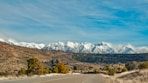 gray concrete road near mountain under blue sky during daytime